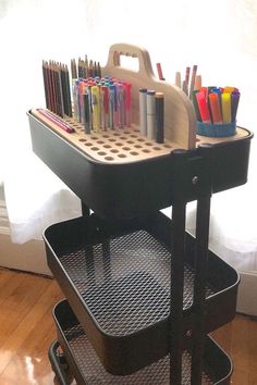 a cart with pens and pencils sitting on top of it