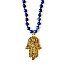 Handcrafted Necklace, hand knotted Lapis Lazuli chain measuring 36", vintage large hand of hamsa pendant, silk velvet emerald green ribbon with a tiny hand and a heart protective evil eye, and vintage brass danglers. The Hamsa Hand is a universal sign of protection, power, and strength that dates back to ancient Mesopotamia. It's believed to protect against the evil eye and all negative energies. Necklace measures 36" in length Lapis Lazuli gemstones hand-knotted Vintage Hand of Hamsa Made with Gold Hand-knotted Necklace For Gift, Gold Hand Knotted Necklace For Gift, Hand-strung Brass Jewelry For Gift, Hand-strung Brass Jewelry Gift, Spiritual Bronze Hand Wrapped Necklaces, Bronze Spiritual Hand Wrapped Necklaces, Handmade Bronze Jewelry For Blessing, Spiritual Hand-knotted Jewelry For Festivals, Bohemian Good Luck Jewelry With 108 Beads