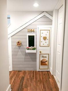 an entry way with a chalkboard on the wall and pictures hanging on the door