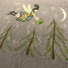 a close up of a piece of fabric with trees on it and a bird in the middle