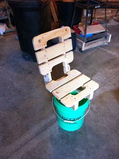 a wooden chair sitting on top of a green bucket