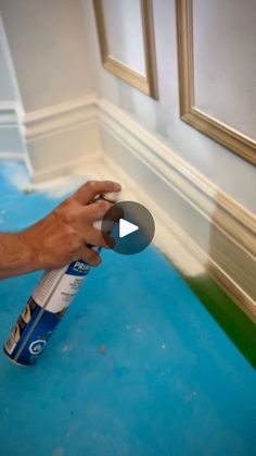 a man is painting the walls with blue paint