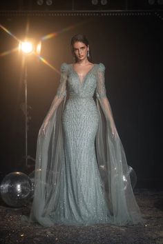 Radiate elegance in our Luxurious Sage Green Sequin Evening Gown. This stunning gown features an exquisite sequin design that shimmers with every movement, ensuring all eyes are on you. The gown is crafted with a sophisticated V-neckline and sheer long sleeves adorned with intricate sequins, exuding grace and glamour. Shimmer Long Dress, Evening Gown With Cape, Simple Satin Wedding Dress, Elegant Cape, Gown With Cape, Nontraditional Wedding Dress, Wedding Dresses High Low, Champagne Evening Dress, Brides Mom