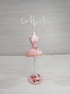 a pink dress on a mannequin with a hanger in the shape of a ballerina