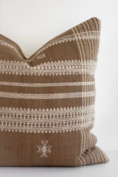 a brown and white pillow sitting on top of a table