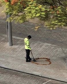 a man is sweeping the sidewalk with a broom