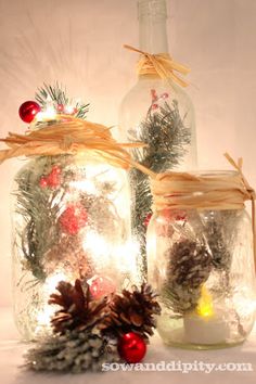 two mason jars filled with pine cones and lights