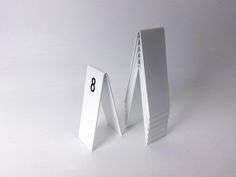 two pieces of white paper are next to each other with numbers on the front and back