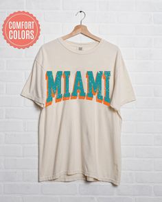 "comfort colors Miami Football shirt, Miami Football Shirt, Retro Miami Football Shirt, Miami Football Gift, Miami Sunday Football -Please check Color and Size Charts before placing the order. You can find them in the listing's photos (Depending on what device you are viewing this listing colors may vary slightly). -Returns and exchanges are accepted only if there are defects \"No Extra Costs\" We create custom t-shirts with great designs for everyone's liking. If you don't find the size or color you would like, please message us and we will be happy to  accommodate! comfort colors Miami Football shirt, Miami Football Shirt, Retro Miami Football Shirt, Miami Football Gift, Miami Sunday Football PRODUCT T-shirt Comfort Colors® 1717     Medium fabric (6.1 oz/yd² (206.8 g/m     Relaxed fit Cotton Graphic Tee Camp Shirt With Letter Print, Cotton Camp Shirt With Letter Print, Casual Camp Shirt With Letter Print And Relaxed Fit, White Relaxed Fit Camp Shirt With Letter Print, Multicolor Short Sleeve T-shirt For College, White Cotton Camp Shirt With Crew Neck, White Cotton Crew Neck Camp Shirt, Miami Football, Football Sunday