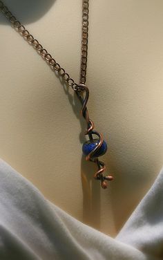 a close up of a necklace on a mannequin's torso with a chain attached to it