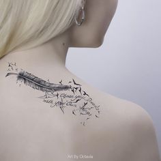 the back of a woman's neck with a feather and flowers tattoo on it