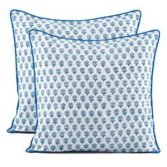 two blue and white pillows sitting next to each other