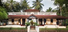 a white house surrounded by palm trees and greenery