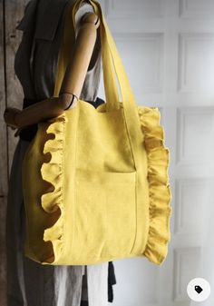 a woman holding a yellow handbag with ruffles on it