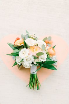 a bouquet of flowers sitting on top of a pink heart