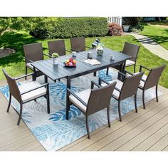 an outdoor table and chairs on a deck