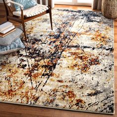 a large rug with an abstract design on the floor in a living room next to a chair