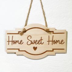 a wooden sign that says home sweet home hanging on a wall with twine cord