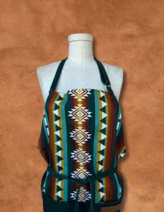 a mannequin wearing an apron made out of fabric with geometric designs on it