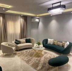 a living room with couches, chairs and a chandelier hanging from the ceiling