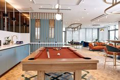 a pool table in the middle of a room with chairs and couches around it