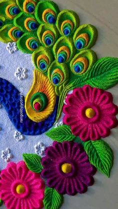 a colorful peacock with flowers and leaves on it's back side, made out of felt