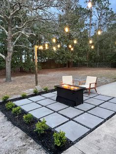 an outdoor fire pit with chairs and lights