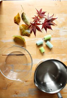 the ingredients are being prepared to cook on the stove top, including apples and leaves