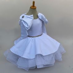 Make your little girl feel like a princess in our enchanting special occasion dress. Crafted from luxurious duchess satin and delicate tulle, this dress exudes elegance and charm. The rhinestone-adorned belt adds a touch of sparkle, making it perfect for weddings, parties, or any special event. Available in sizes for girls, toddlers, and baby girls, this dress is sure to make her feel extra special on any memorable occasion. Size Guide: 1) All our Gowns can be made in any size ranging from girls 3-6 months to Adult Plus Sizes. 2) Ordering based on Size Chart: Before you place your order please compare your measurements to the size chart provided. 3) Ordering Custom: If you choose to submit custom measurements, we will be adding an inch to the chest and waist circumference to allow room for Playful White Tutu Dress For Birthday, Luxury White Princess Tutu Dress, Luxury White Tutu Dress For Dress-up, White Tulle Baptism Dress With Satin Bow, Satin Flower Girl Dress With Pearls, Duchess Satin, Baby Frocks Designs, Flower Girl Dresses Tulle, Frock Design