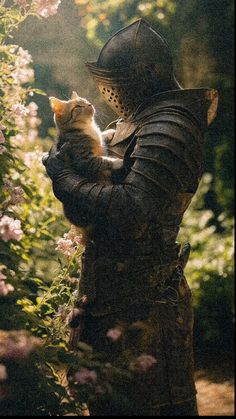 a man holding a cat in his arms while wearing a helmet and leather jacket with flowers behind him