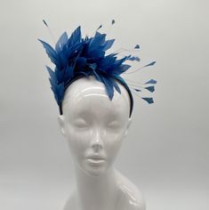 Handmade by Featured Milliner of The Kentucky Derby Museum 2023 & 2024! Lake blue feather mounts on coordinating silk headband. Attaches with headband.  Not taking customs this year--Derby 150 is going to be massive and mom life keeps me running! However, happy to suggest pieces that will coordinate with your outfit. If you don't love the way this attaches to your head--message me!  I can swtich *most* pieces to your preference. Clip, Headband OR Elastic Cord  NOTE: Heavier pieces with extravagant florals etc require the stability of a headband. NO RETURNS/EXCHANGES due to nature of product (special occasion and head wear). Not all screens/lighting are created equal. Make sure you are happy with the color match before ordering! If you have any concerns, let me know--here to help. Just say Head Message, Clip Headband, Derby Fascinator, Silk Headband, Head Wear, Kentucky Derby Hat, Derby Hat, Blue Feather, Silver Line