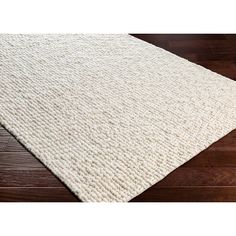 a white rug on top of a wooden floor