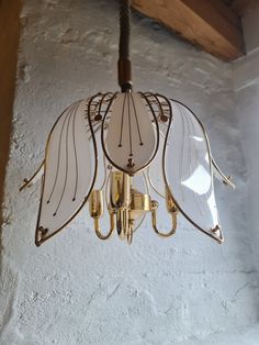 a chandelier hanging from the ceiling in a room with white walls and wooden beams