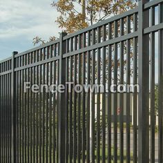 the fence is made of metal and has black slats on it, along with a red fire hydrant