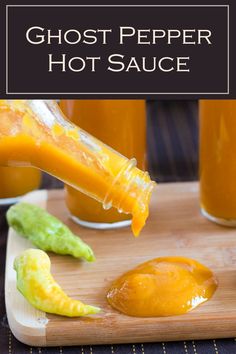 there is a bottle of ghost pepper hot sauce on the cutting board with other condiments