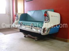 a blue and white couch sitting on top of a wooden floor next to a red wall