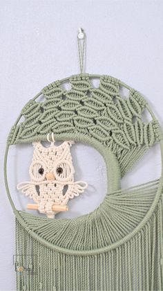 an owl made out of yarn hanging on a wall