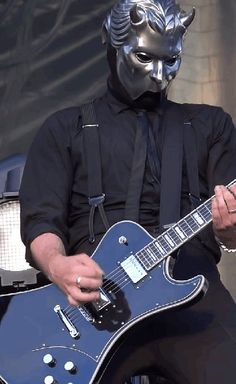 a man wearing a mask playing an electric guitar