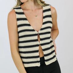 a woman wearing a black and white striped vest