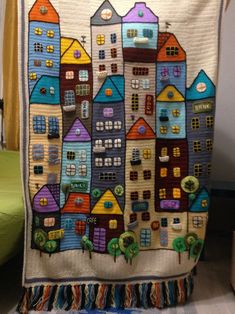 a quilted wall hanging with houses on it