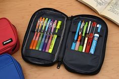 an open case filled with lots of different colored pens and pencils on a table