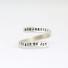 Wrap ring with quote by Theodore Roosevelt "Comparison is the Thief of Joy" Hand forged and hand stamped by maker, Christine Street. Theodore Roosevelt Jr., often referred to as Teddy, was an American politician, statesman, conservationist, naturalist, historian, and writer who served as the 26th president of the United States from 1901 to 1909. This quote evokes a powerful sentiment that can be life-changing. If we compare ourselves to others, we may be left with feelings of inferiority or supe Inspirational Adjustable Hand Stamped Rings, Adjustable Inspirational Stamped Rings, Inspirational Hand-stamped Rings For Gifts, Adjustable Hand-forged Engraved Ring For Anniversary, Adjustable Hand Forged Engraved Ring, Theodore Roosevelt Quotes, Roosevelt Quotes, Theodore Roosevelt, Wrap Ring