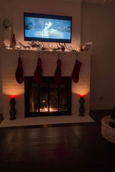 a living room with a fire place and christmas stockings on the mantel