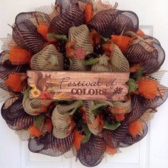 a wreath with the words festival of color on it is hanging on a white door