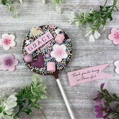 a cake on a stick with flowers around it