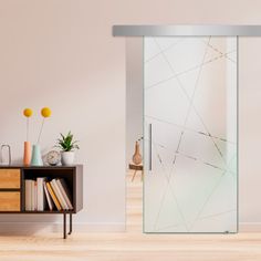 a room with a book shelf and a sliding glass door that has an abstract design on it