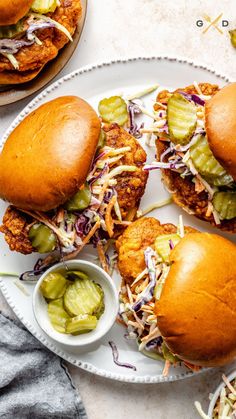 two chicken sliders with pickles and coleslaw on a plate