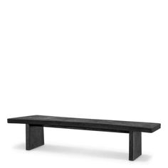 a black bench sitting in front of a white wall