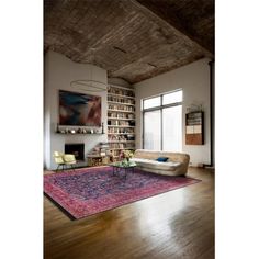 a living room filled with furniture and a large rug on top of a hard wood floor