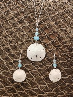 "Gorgeous natural sand dollar necklace with matching earring set. The sand dollars are real and are in their natural condition, and accented with beads in varying shades blue. This would be a gorgeous set for a beach wedding for a bride. bridesmaids, or just a gift for the beach lover in your life. The pendant (approximately 1.5\" across) is set on an 18\", anti-tarnish stainless steel chain that sparkles in the light. Multiple sizes of chain are available. The set is also available in stainless Crafts To Do With Sand Dollars, Turquoise Dangle Earrings With Ocean-inspired Style, Nickel Free Ocean-inspired Pendant Jewelry, Turquoise Dangle Earrings Ocean-inspired, Nickel-free Ocean-inspired Pendant Jewelry, Handmade Ocean-inspired Round Pendant Jewelry, Ocean-inspired Turquoise Dangle Jewelry, Turquoise Jewelry With Matching Earrings For Beach, Nickel-free Ocean-inspired Round Pendant Jewelry